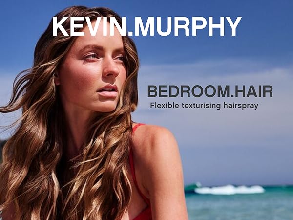 A woman with long, wavy light brown hair stands outdoors against a blue sky and ocean background. Large text reads 'KEVIN.